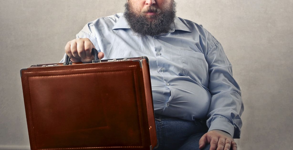 رجل سمين يجلس بيده شنطة